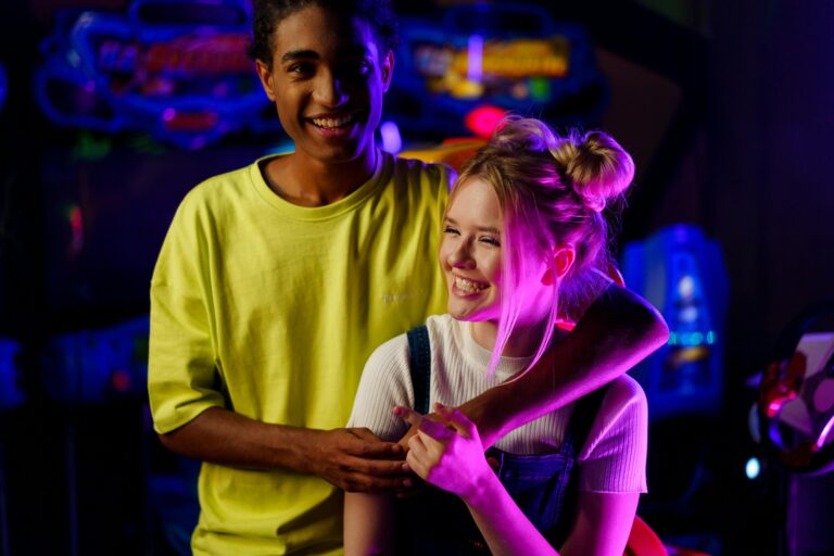 pexels-photo-5767689-5767689-1 - Readers And Healers Inc. Smiling couple bonding at a vibrant arcade with gaming machines.